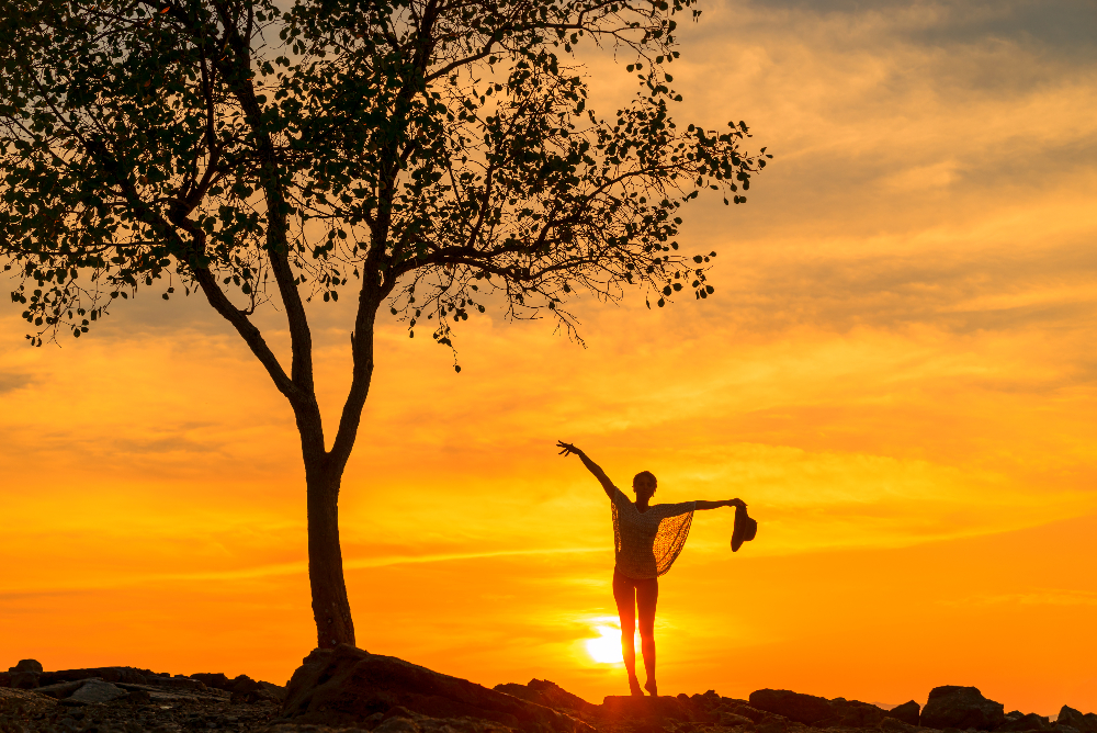 woman doing yoga at sunset