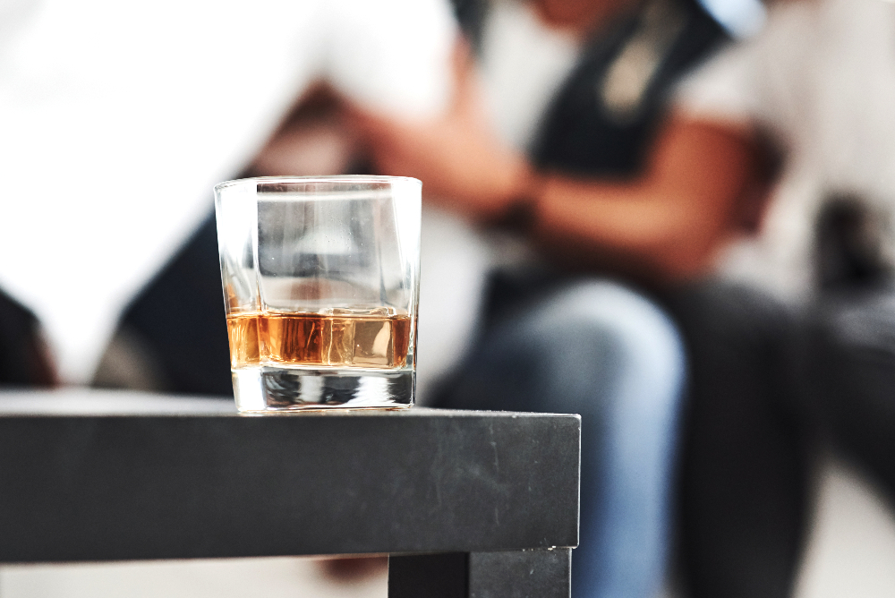 glass of whiskey sitting on table