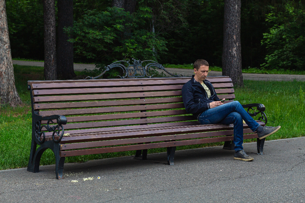 man sitting on bench alone at a park in sacramento  mood disorder treatment