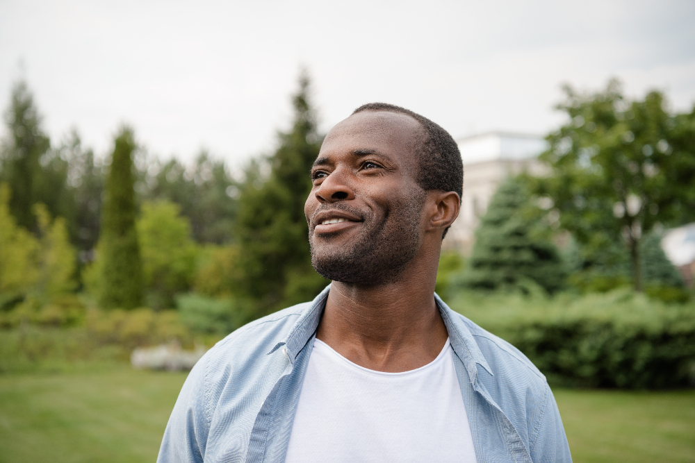 african american man standing in grassy field after overcoming substance use disorder