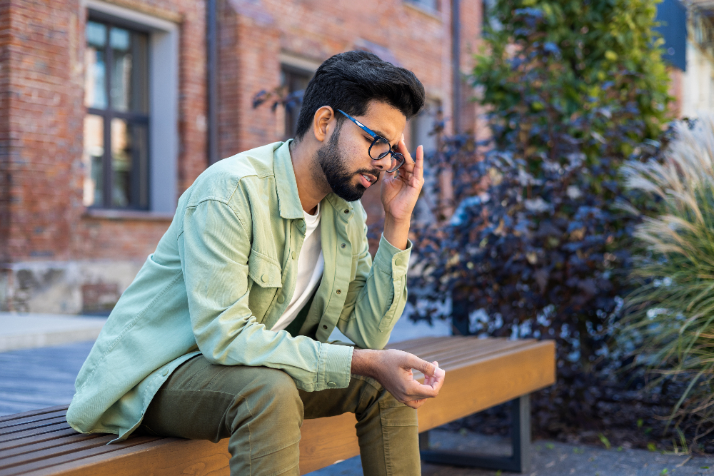 man sitting outside on bench struggling with depression