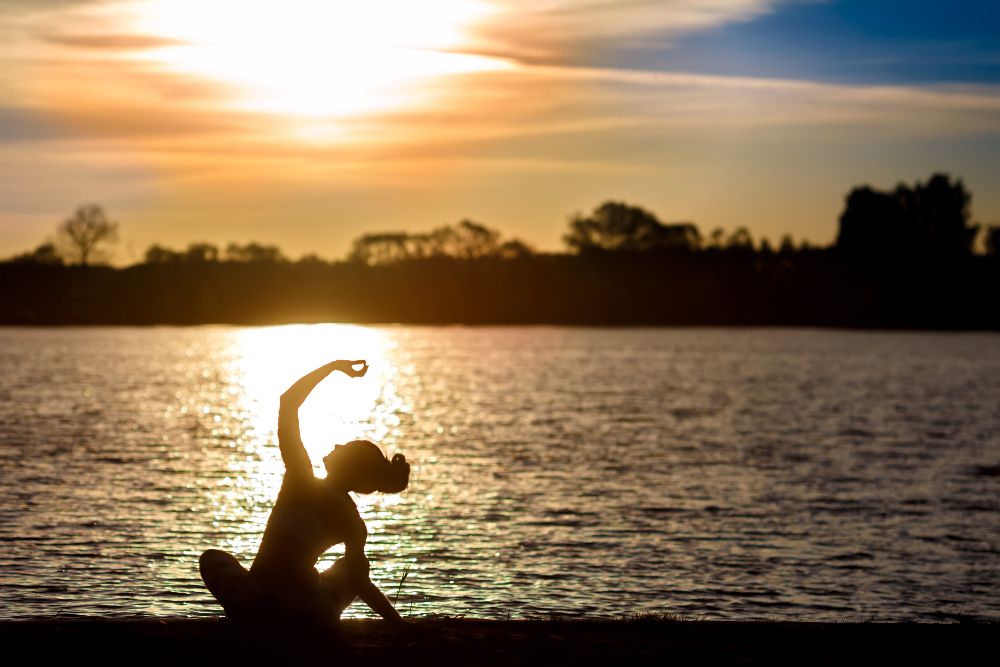 woman practicing yoga and mindfulness at sunset