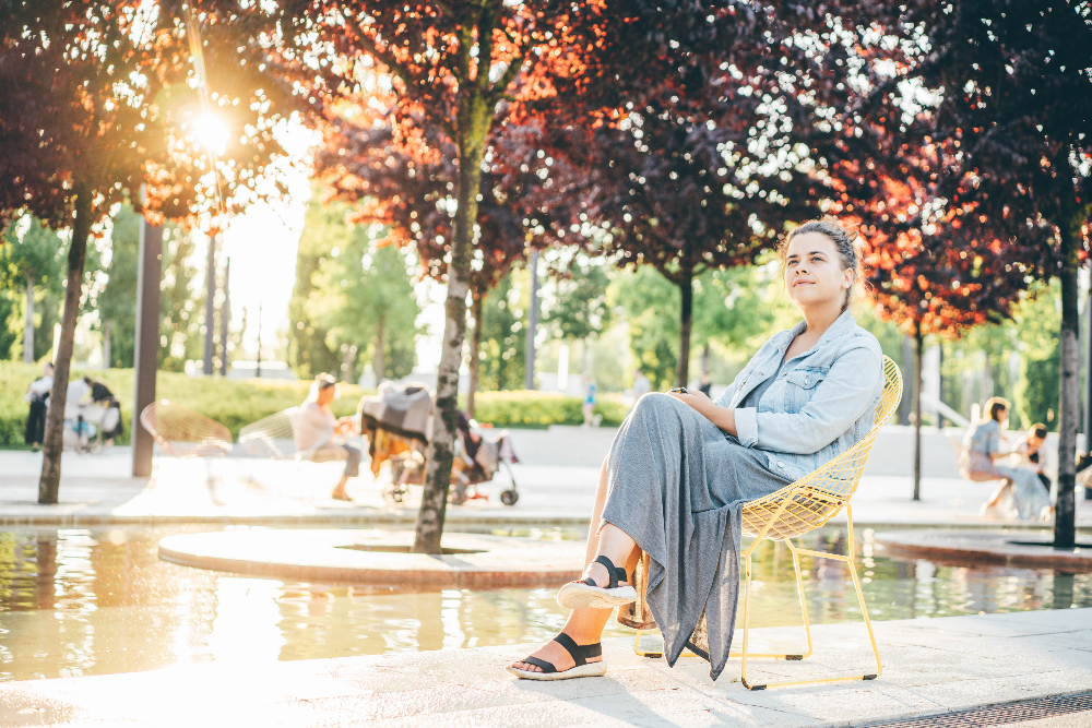 woman with persistent depressive disorder sitting ona bench at a park in sacramento