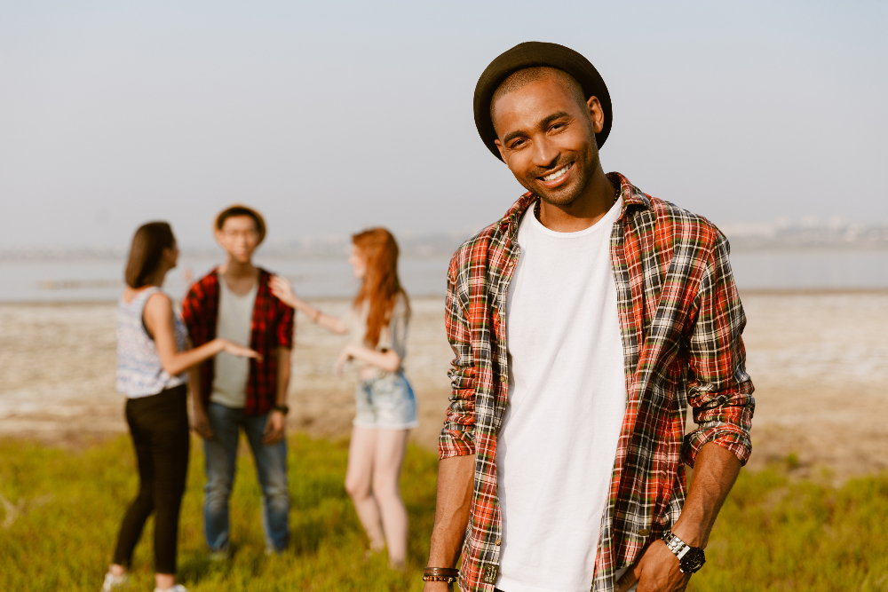 man smiling outside with friends