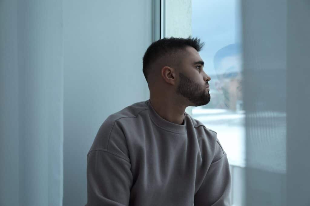 Contemplative man gazing out a window indoors