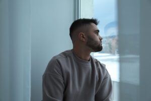 Contemplative man gazing out a window indoors
