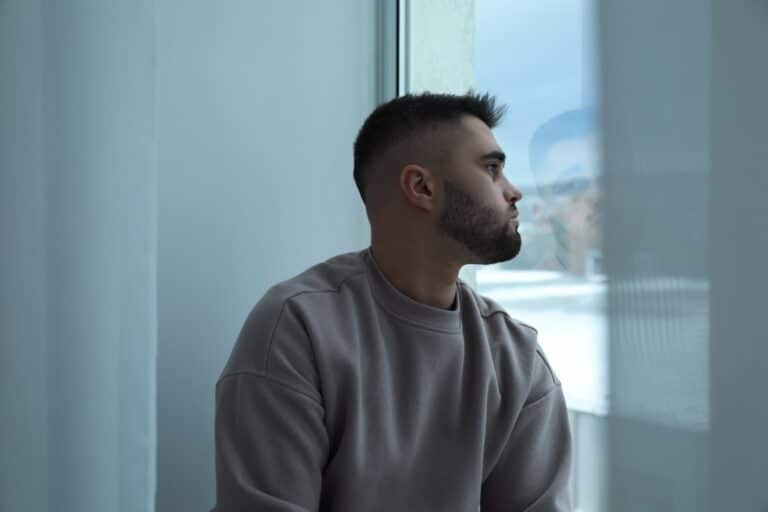 Contemplative man gazing out a window indoors