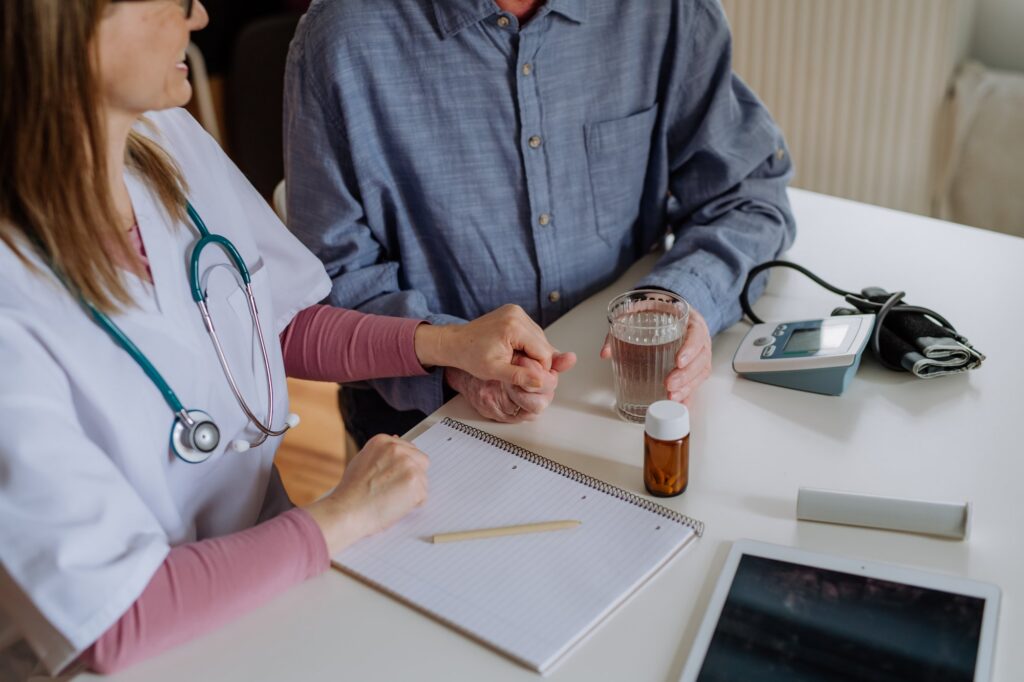 Doctor in a white coat consulting and reassuring a patient during a medical visit