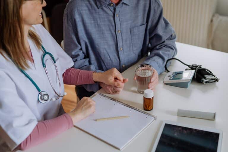 Doctor in a white coat consulting and reassuring a patient during a medical visit
