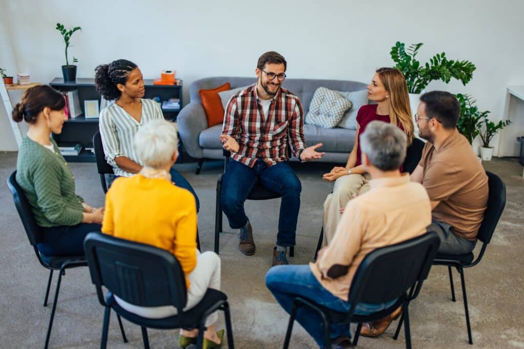 Adults sitting in a circle during a support group therapy session
