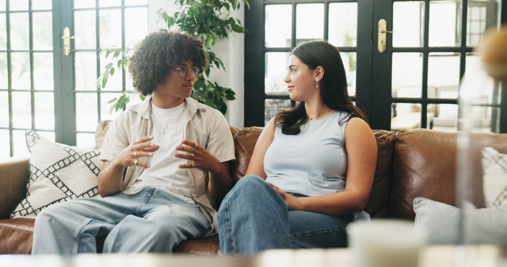Two adults having a calm, supportive conversation on a couch