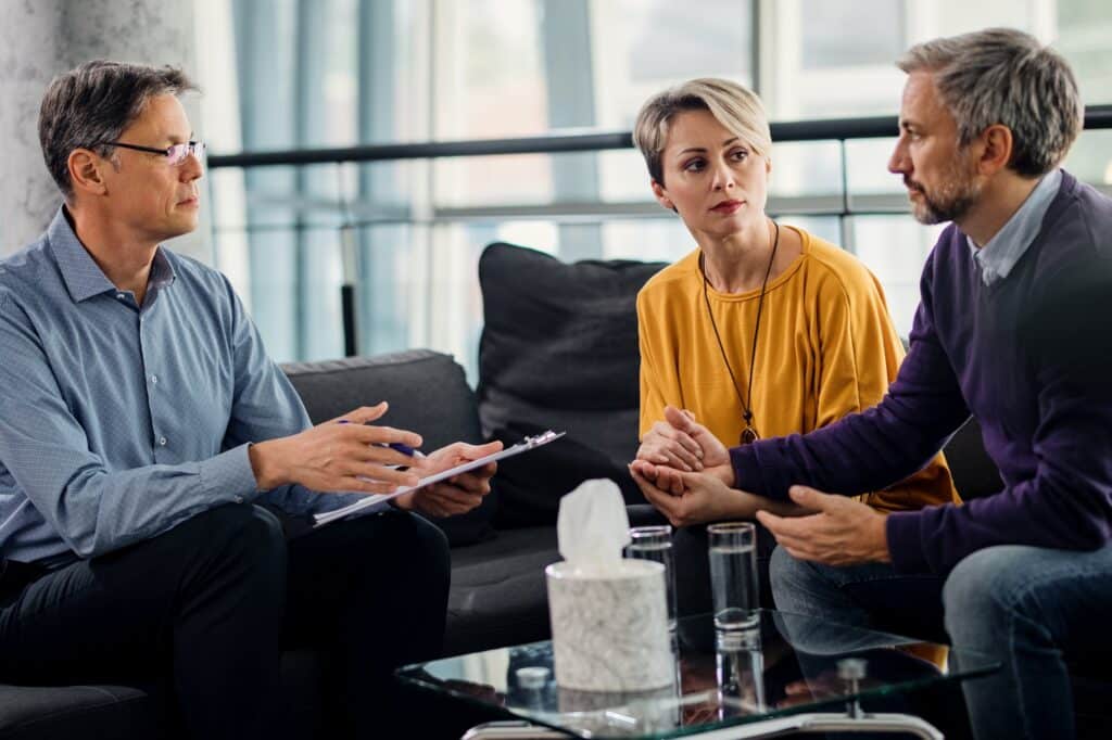A counselor meeting with an adult couple in a therapy session