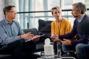 A counselor meeting with an adult couple in a therapy session